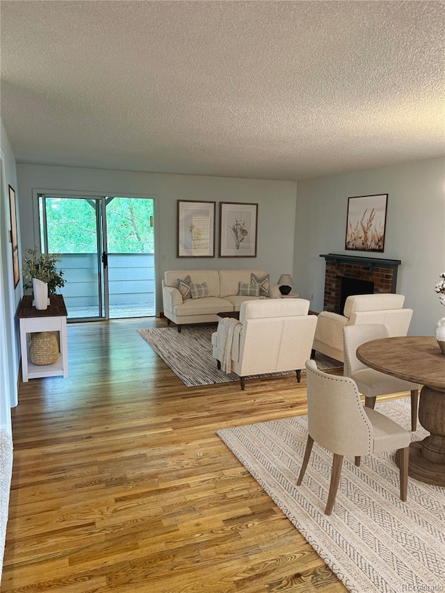 10369 E Red Mtn, Littleton, CO 80127 - living room with light wood-style flooring, a textured ceiling, and a fireplace