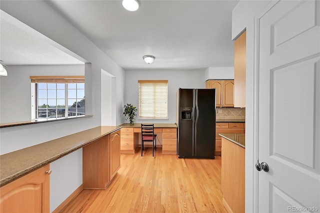 10369 E Red Mtn, Littleton, CO 80127 - kitchen featuring black refrigerator with ice dispenser, light wood finished floors, plenty of natural light, and backsplash