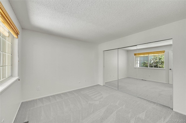 10369 E Red Mtn, Littleton, CO 80127 - unfurnished bedroom featuring carpet floors, a textured ceiling, a closet, and baseboards