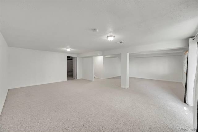 10369 E Red Mtn, Littleton, CO 80127 - finished below grade area with light carpet, a textured ceiling, baseboards, and stairs