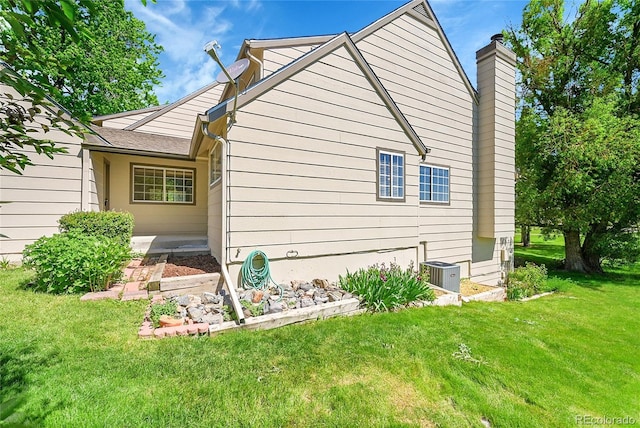 10369 E Red Mtn, Littleton, CO 80127 - view of side of home with a yard, central AC unit, and a chimney