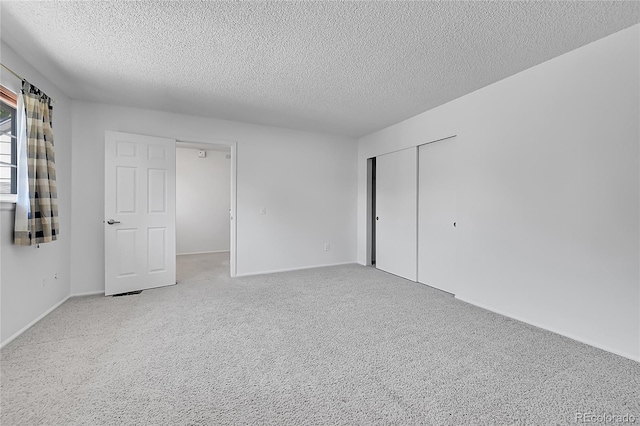 10369 E Red Mtn, Littleton, CO 80127 - unfurnished bedroom featuring a textured ceiling, light carpet, a closet, and baseboards