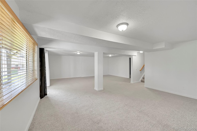 10369 E Red Mtn, Littleton, CO 80127 - below grade area with a textured ceiling, baseboards, light colored carpet, and stairway