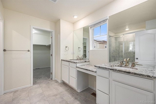 26267 E 3rd Ave, Aurora, CO 80018 - bathroom featuring a shower stall, a spacious closet, and two vanities