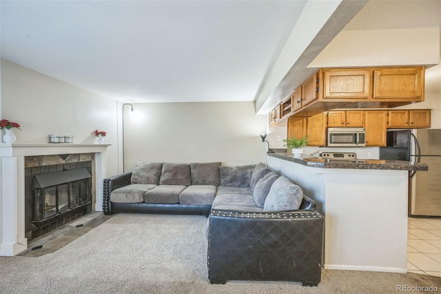 living area with a fireplace, light carpet, and light tile patterned floors