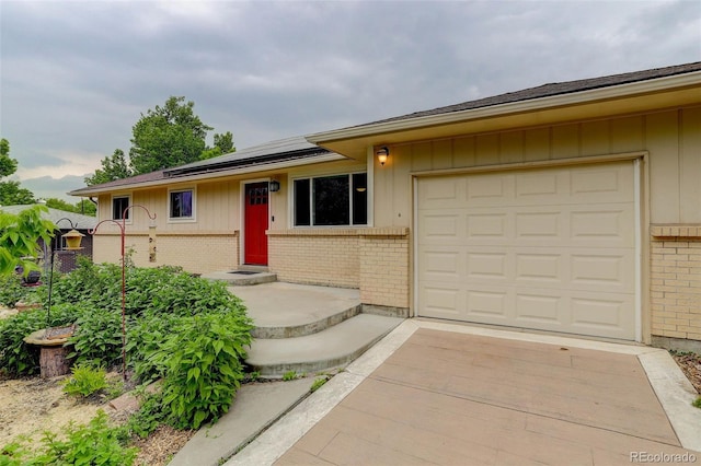 9743 W 67th Pl, Arvada, CO 80004 - single story home with brick siding, roof mounted solar panels, a garage, and driveway