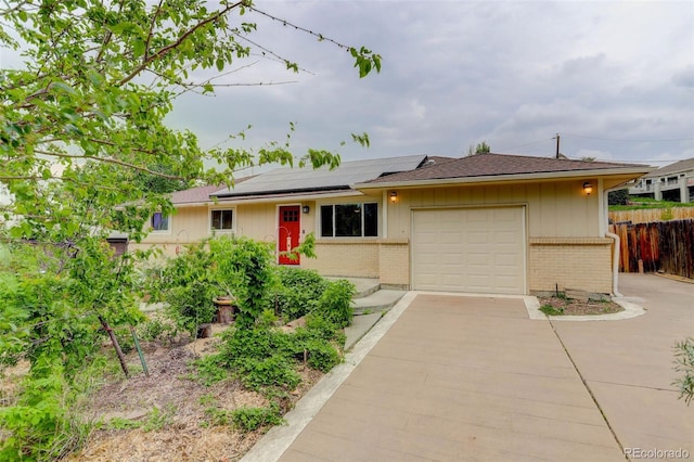 9743 W 67th Pl, Arvada, CO 80004 - single story home featuring an attached garage, driveway, roof mounted solar panels, and brick siding