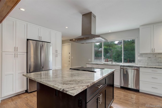 9743 W 67th Pl, Arvada, CO 80004 - kitchen featuring appliances with stainless steel finishes, island range hood, white cabinets, light stone counters, and recessed lighting