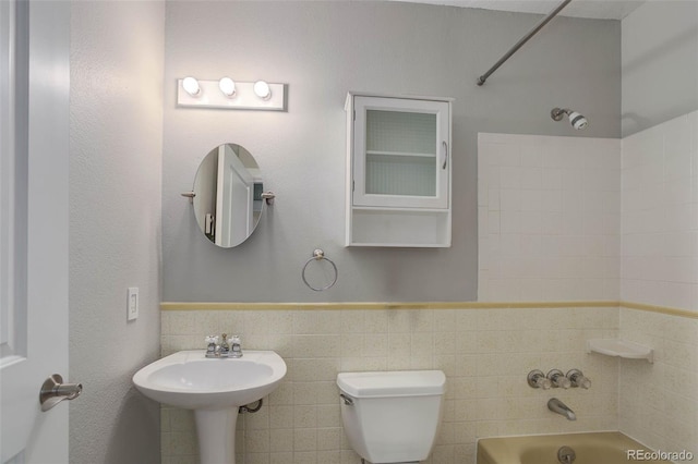 9743 W 67th Pl, Arvada, CO 80004 - full bath featuring toilet, bathtub / shower combination, tile walls, a sink, and wainscoting
