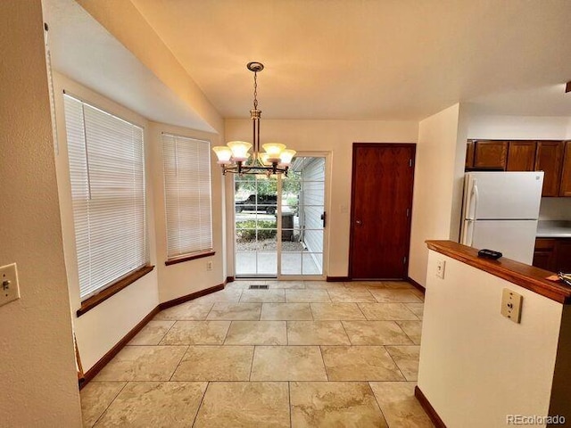 1115 W Swallow Rd Unit 20, Fort Collins, CO 80526 - unfurnished dining area with a chandelier and baseboards