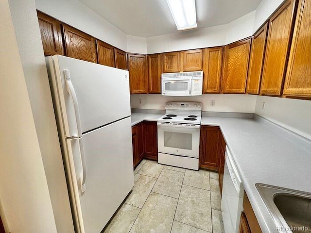 1115 W Swallow Rd Unit 20, Fort Collins, CO 80526 - kitchen with white appliances, light countertops, brown cabinets, and light tile patterned floors