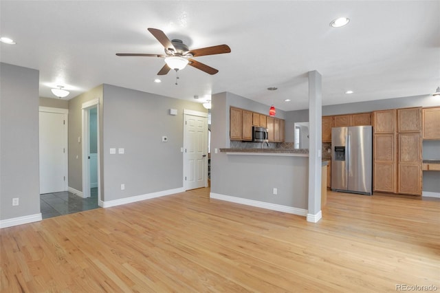 unfurnished living room featuring ceiling fan and light wood-type flooring