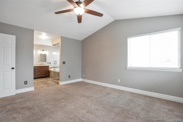 unfurnished bedroom featuring lofted ceiling, light carpet, connected bathroom, and ceiling fan