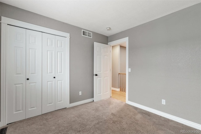 unfurnished bedroom featuring a closet and light carpet