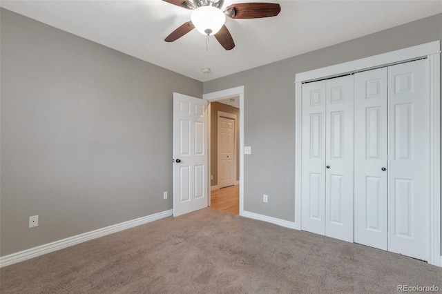 unfurnished bedroom featuring light colored carpet, a closet, and ceiling fan