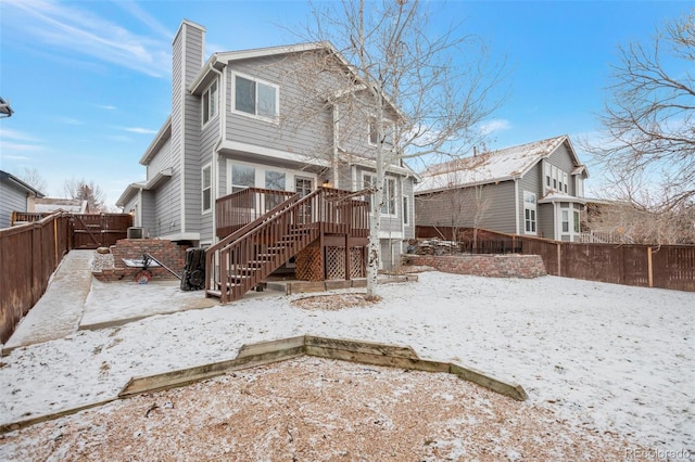 snow covered house with a deck