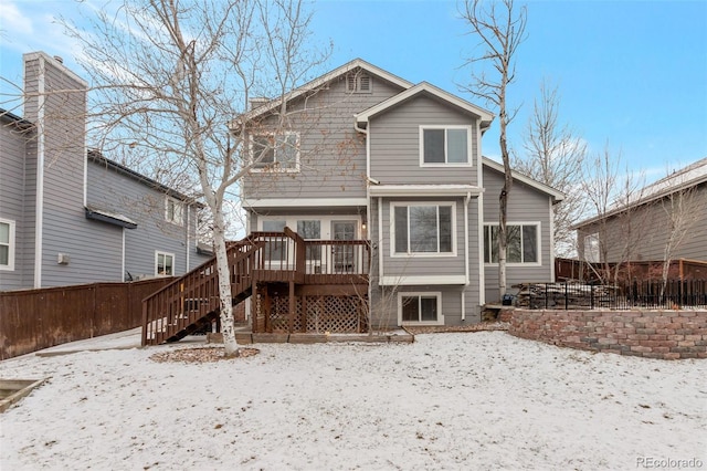 snow covered back of property featuring a wooden deck