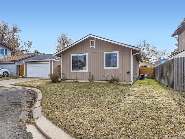 view of front of house featuring a garage, a front yard, and central AC