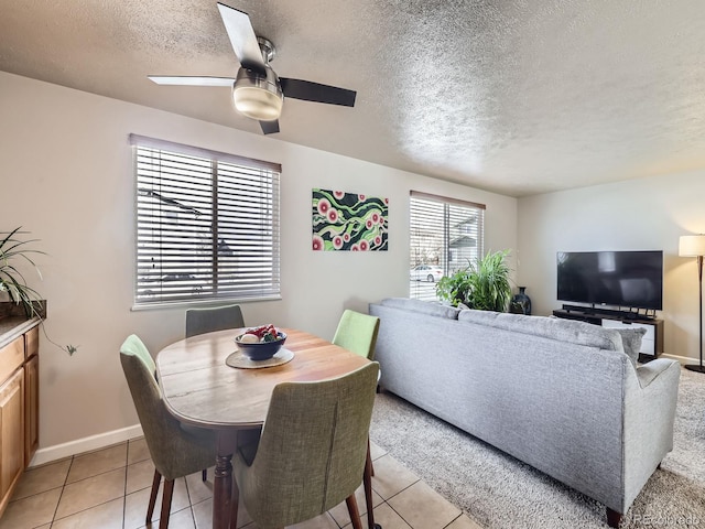 dining space with ceiling fan, light tile patterned flooring, and a textured ceiling