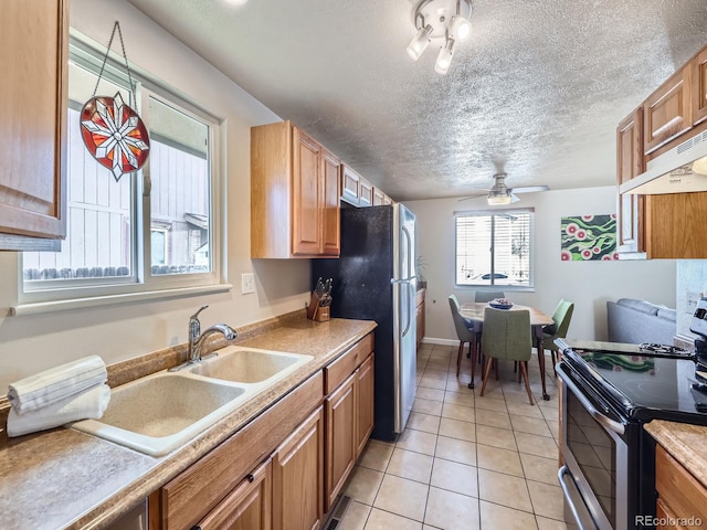 kitchen featuring ventilation hood, sink, ceiling fan, light tile patterned floors, and appliances with stainless steel finishes