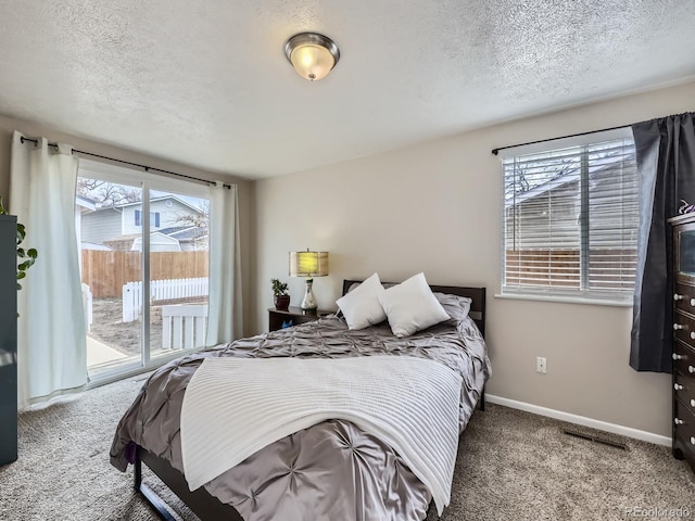 carpeted bedroom with access to exterior and a textured ceiling