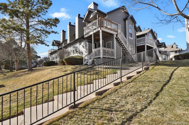 view of side of property with a fenced front yard, a chimney, and a yard