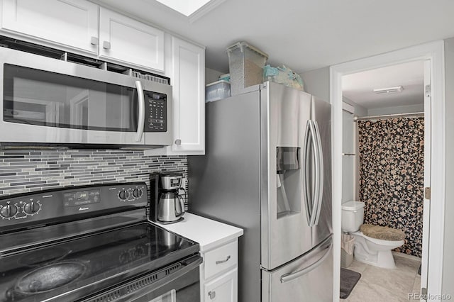 kitchen featuring stainless steel appliances, light countertops, backsplash, and white cabinetry