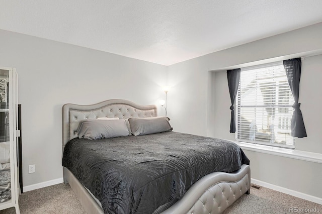 bedroom featuring a textured ceiling, carpet flooring, and baseboards