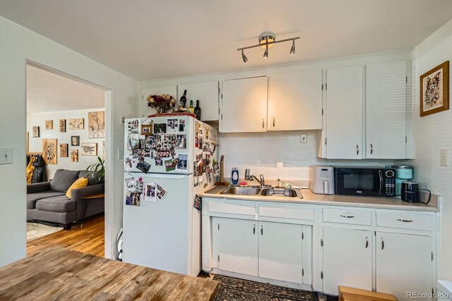 5424 Saulsbury Ct, Arvada, CO 80002 - kitchen featuring black microwave, freestanding refrigerator, a sink, light countertops, and light wood-style floors