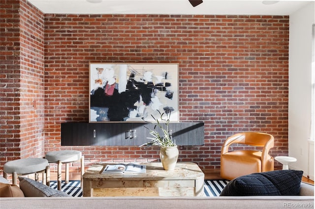 living area featuring brick wall