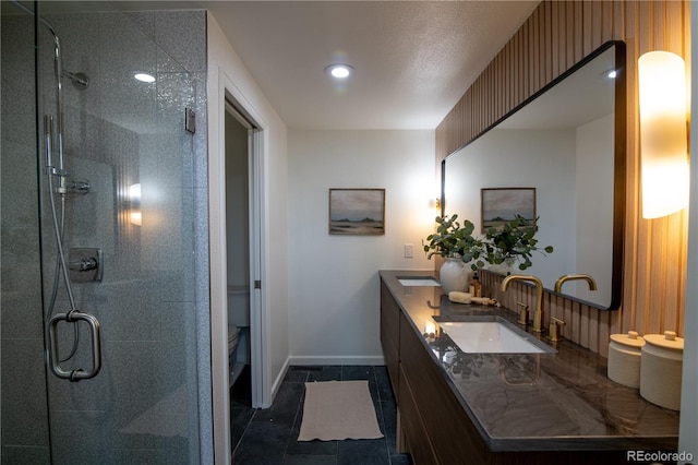 7600 S Ulster Ct, Centennial, CO 80112 - bathroom with a shower stall, baseboards, double vanity, toilet, and recessed lighting