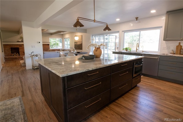 7600 S Ulster Ct, Centennial, CO 80112 - kitchen featuring a sink, appliances with stainless steel finishes, open floor plan, wood finished floors, and recessed lighting
