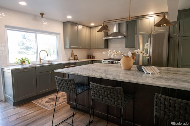 7600 S Ulster Ct, Centennial, CO 80112 - kitchen with stainless steel appliances, wall chimney exhaust hood, a sink, light stone counters, and gray cabinets