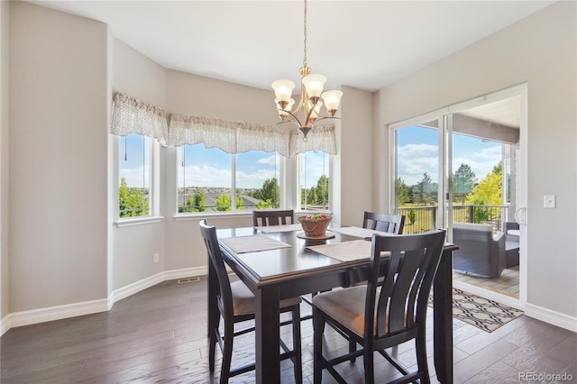 dining area featuring an inviting chandelier, a healthy amount of sunlight, and dark hardwood / wood-style floors