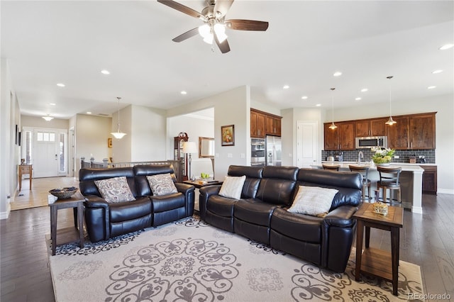 living room with ceiling fan and light hardwood / wood-style flooring