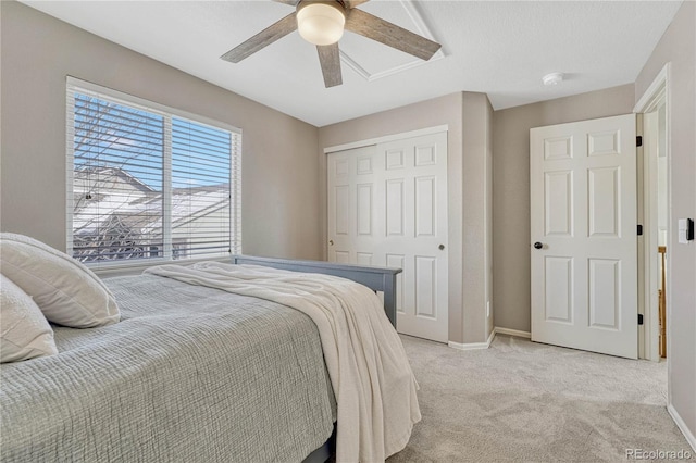 carpeted bedroom featuring ceiling fan and a closet