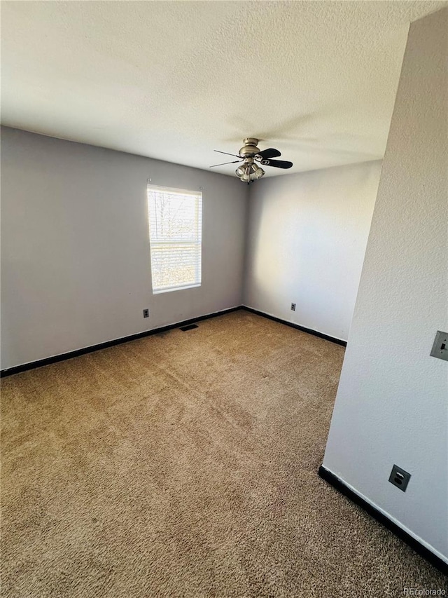 carpeted empty room featuring ceiling fan and a textured ceiling