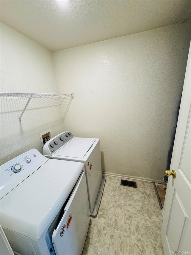 washroom featuring separate washer and dryer and a textured ceiling