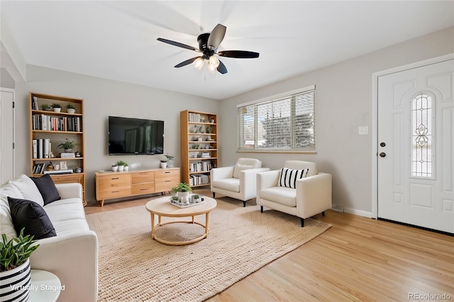 living room featuring ceiling fan and light hardwood / wood-style floors