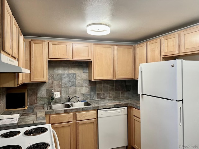 kitchen with light brown cabinetry, white appliances, under cabinet range hood, tasteful backsplash, and a sink