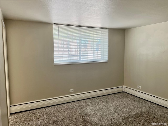 carpeted spare room featuring a textured ceiling and a baseboard heating unit