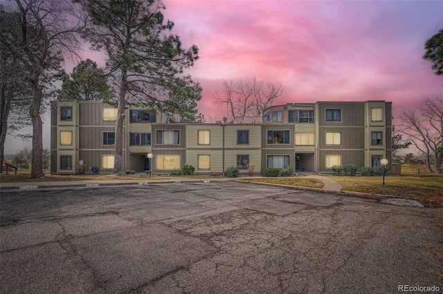 property at dusk featuring uncovered parking