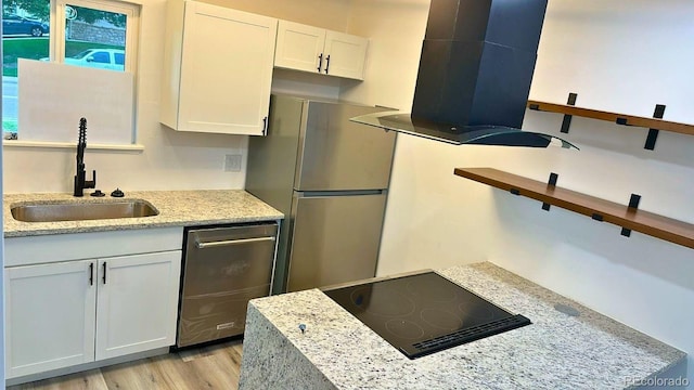 2218 Coronado Pkwy N Unit B, Denver, CO 80229 - kitchen with exhaust hood, stainless steel appliances, white cabinets, light wood finished floors, and light stone countertops