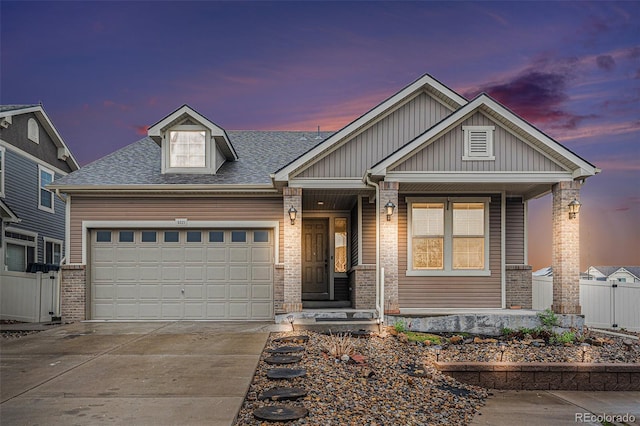 5521 Ensenada St, Denver, CO 80249 - view of front facade with concrete driveway, a porch, an attached garage, brick siding, and a shingled roof