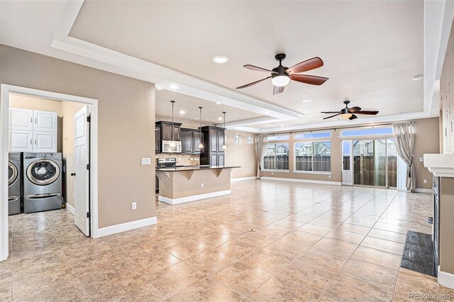 5521 Ensenada St, Denver, CO 80249 - unfurnished living room with a tray ceiling, washer and clothes dryer, ceiling fan, baseboards, and recessed lighting