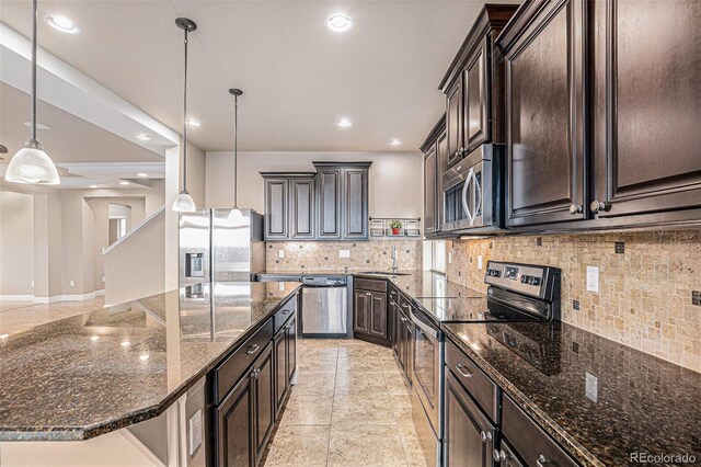 5521 Ensenada St, Denver, CO 80249 - kitchen with appliances with stainless steel finishes, a sink, backsplash, recessed lighting, and dark stone countertops