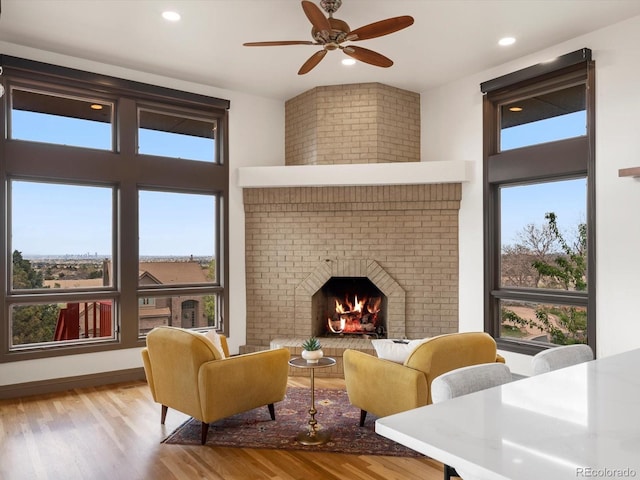 43 Falcon Hills Dr, Highlands Ranch, CO 80126 - living room featuring a ceiling fan, wood finished floors, a healthy amount of sunlight, and a fireplace