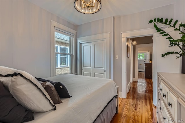 3259 Lowell Blvd, Denver, CO 80211 - bedroom featuring wood finished floors, a closet, and a chandelier
