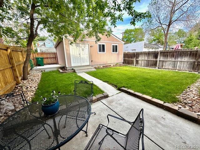 3259 Lowell Blvd, Denver, CO 80211 - fenced backyard with a patio, outdoor dining space, and an outbuilding