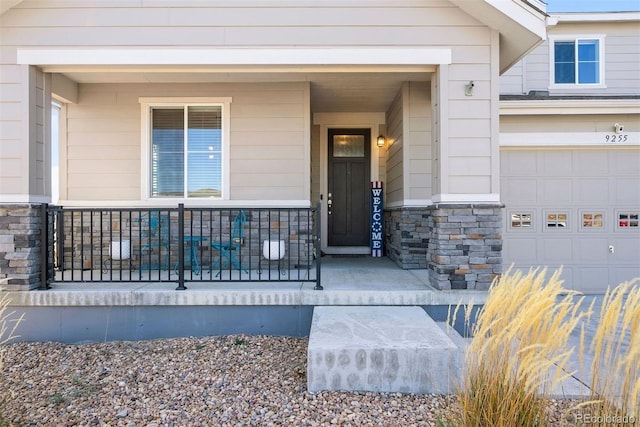 entrance to property with covered porch and a garage